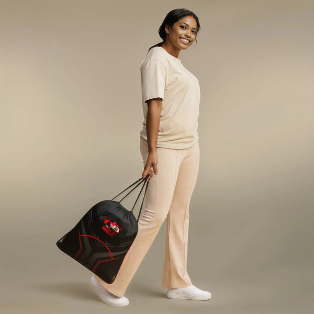 Viv'ed the Artist drawstring bag in black with red and gray details, carried by a woman in beige athleisure wear for a sporty and stylish look.