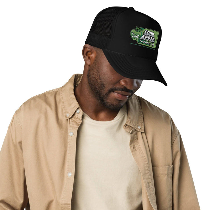 Man styling a black Sour Apple Foam Trucker Hat with green apple logo, suitable for sports and casual wear.