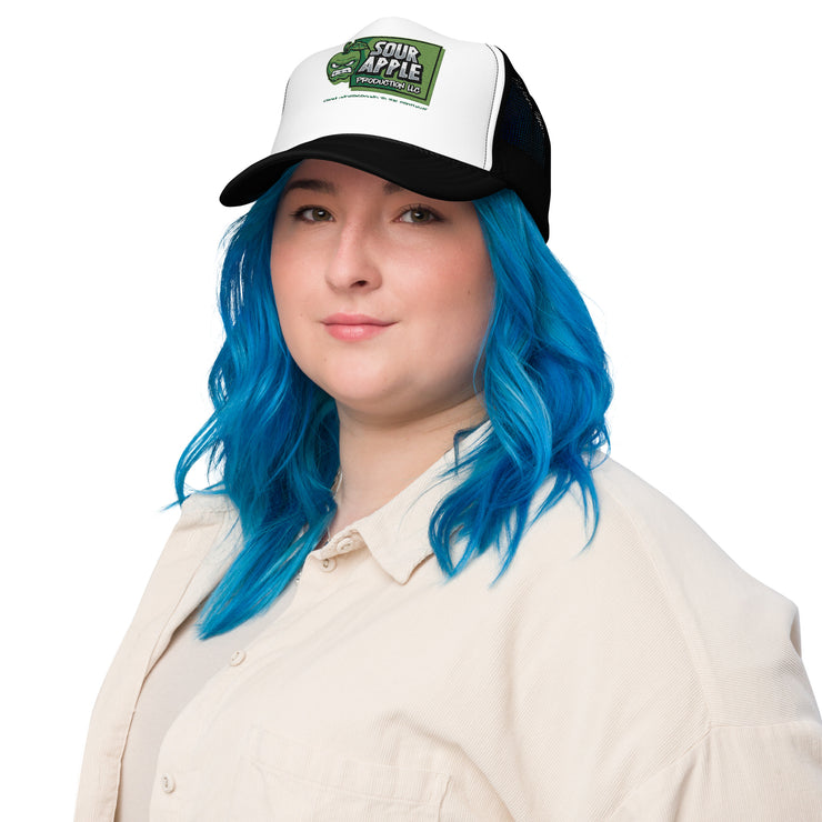 Model wearing a white and black Sour Apple Foam Trucker Hat with green apple logo, ideal for athleisure and casual wear.