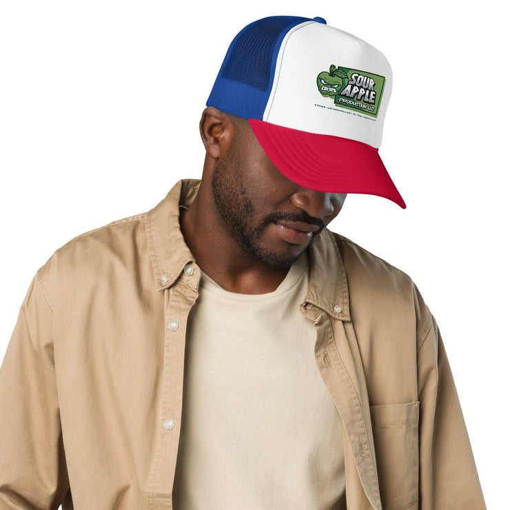 Man wearing a white, red, and blue Sour Apple Foam Trucker Hat with green apple logo, perfect for casual outings and fan gear.
